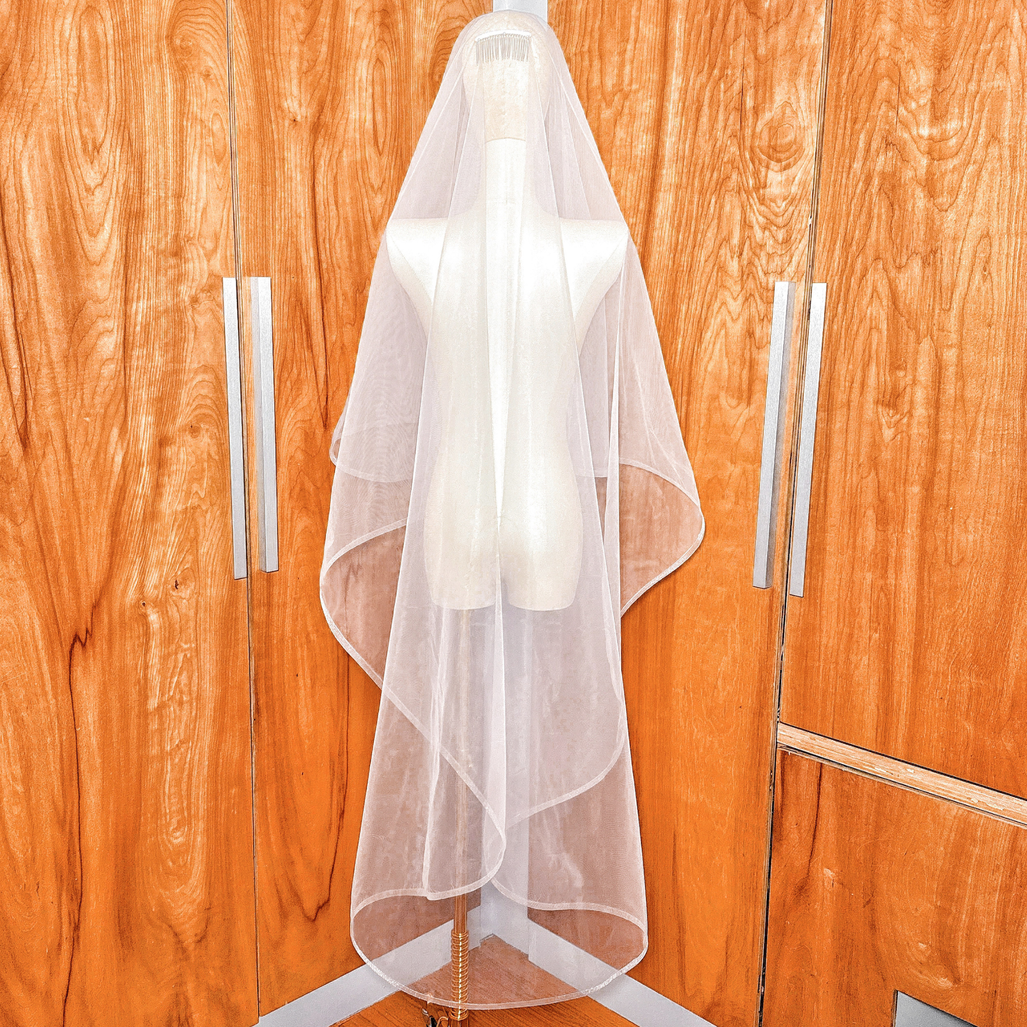Back view of a two tier wedding veil with 1/2" horsehair trim in waltz length displayed on a bridal mannequin.