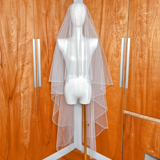Waltz length two tier wedding veil with a clean pencil edge and blusher displayed on a bridal mannequin.