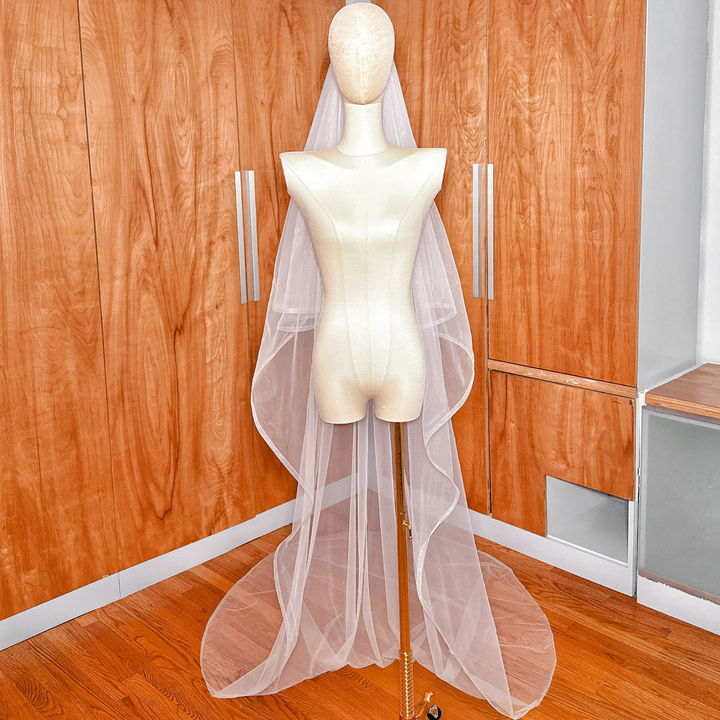 A bridal two-tier cathedral veil with horsehair trim and a blusher layer for a traditional wedding look.