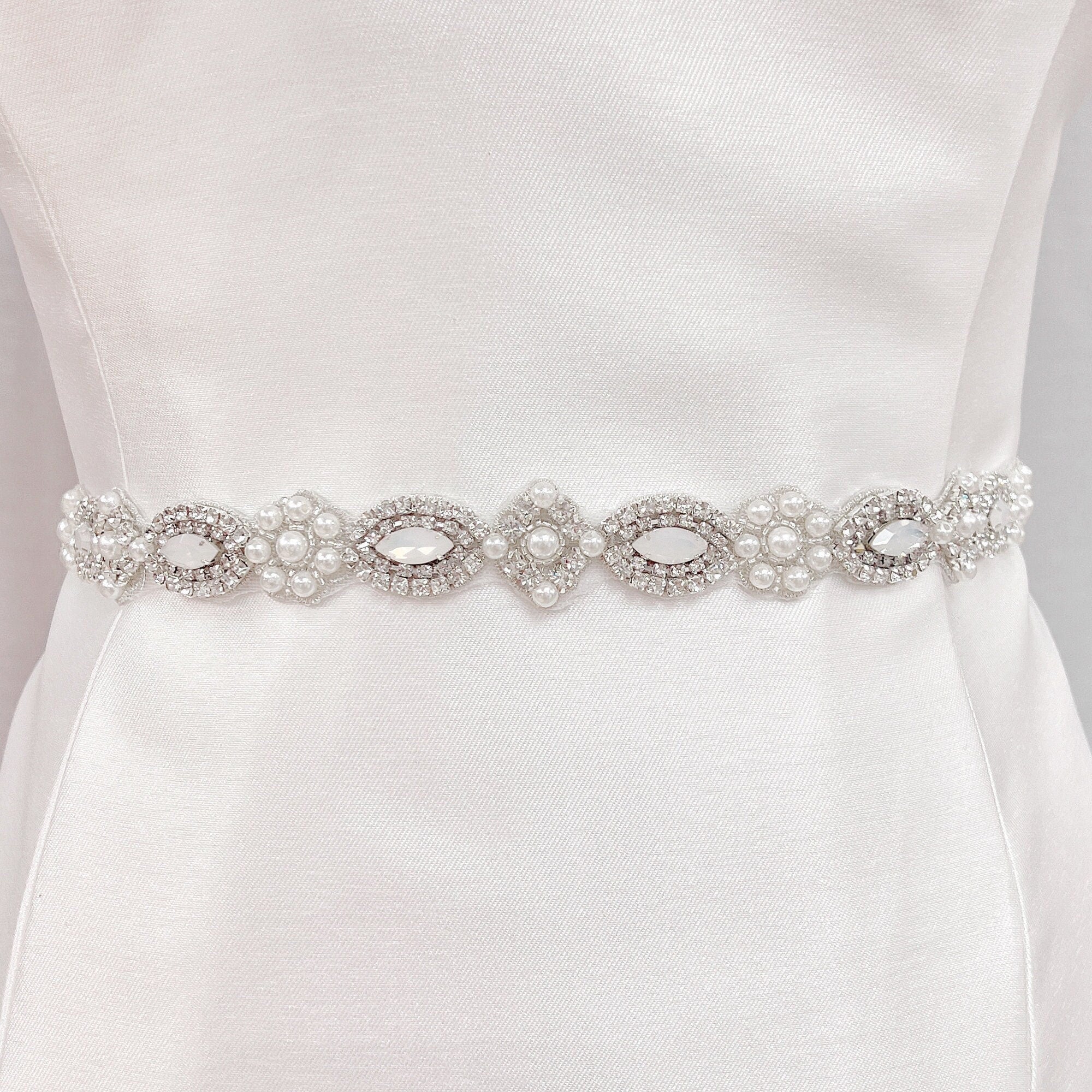 Art Deco beaded wedding belt with intricate silver geometric crystal patterns on a display bridal mannequin.