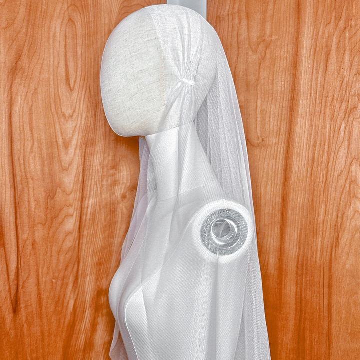 Close-up detail of the vintage-inspired cap on a Juliet style wedding veil, featuring a clean raw edge finish.