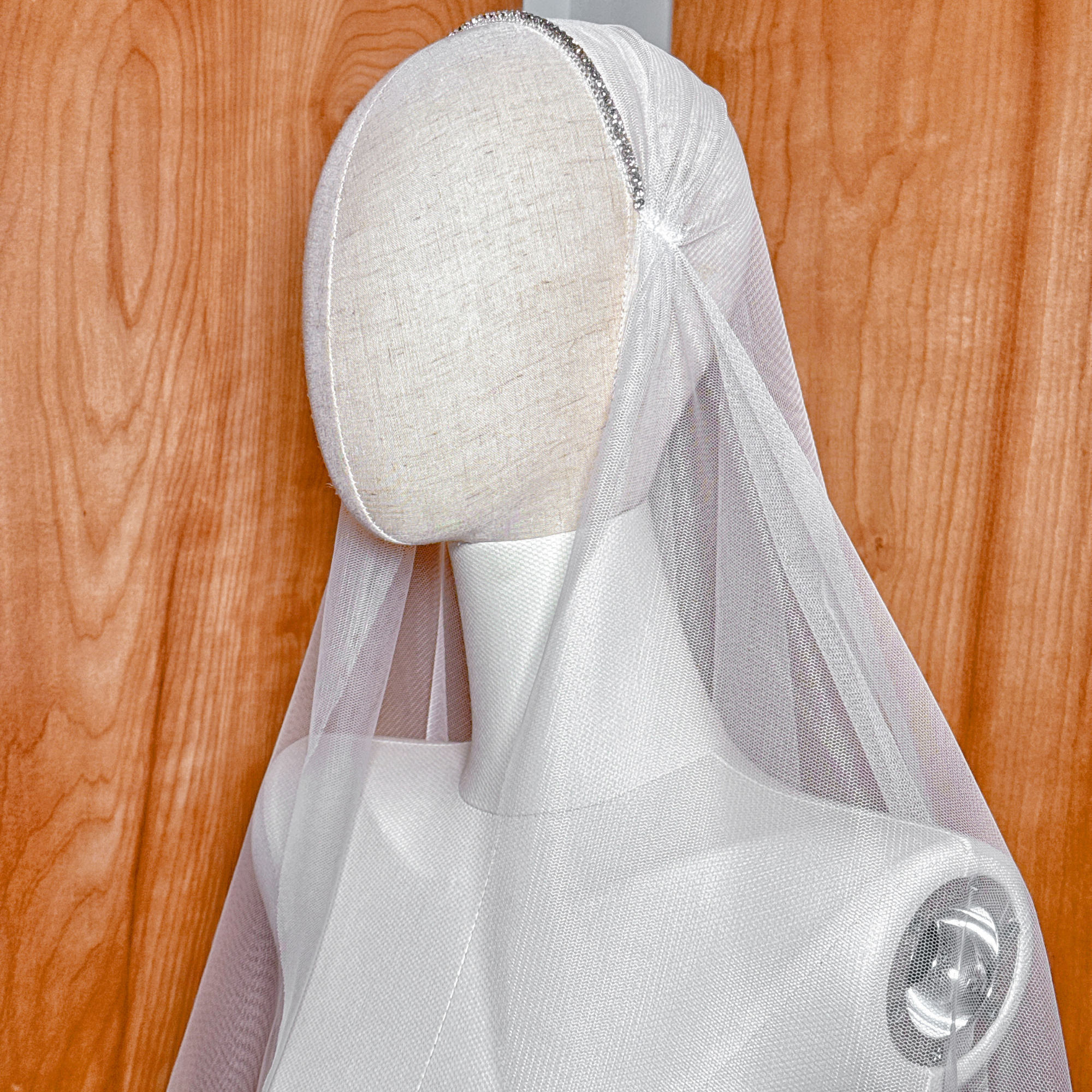 Vintage-inspired beaded Juliet cap bridal veil in fingertip length on a mannequin.