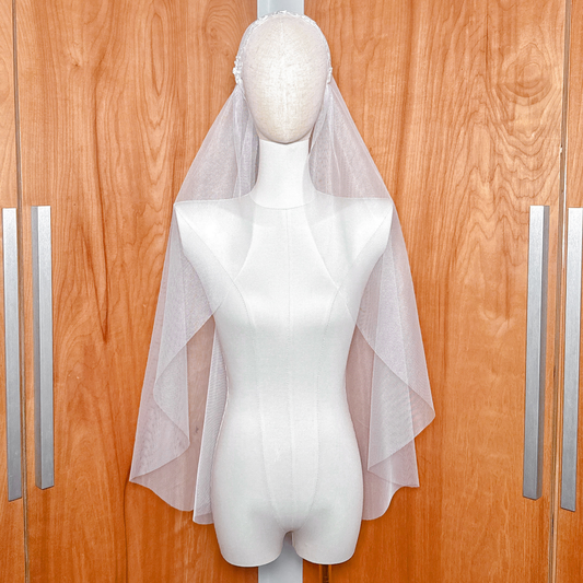 Front view of a vintage style Juliet cap veil with intricate beaded lace detailing displayed on a mannequin.