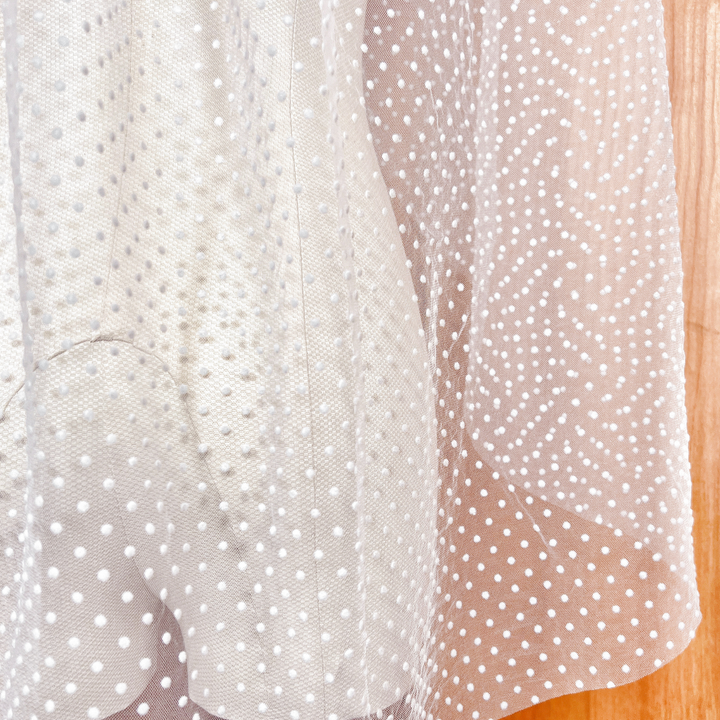 Back view of a 1950s-inspired polka dot bridal veil in fingertip length, highlighting its retro aesthetic.