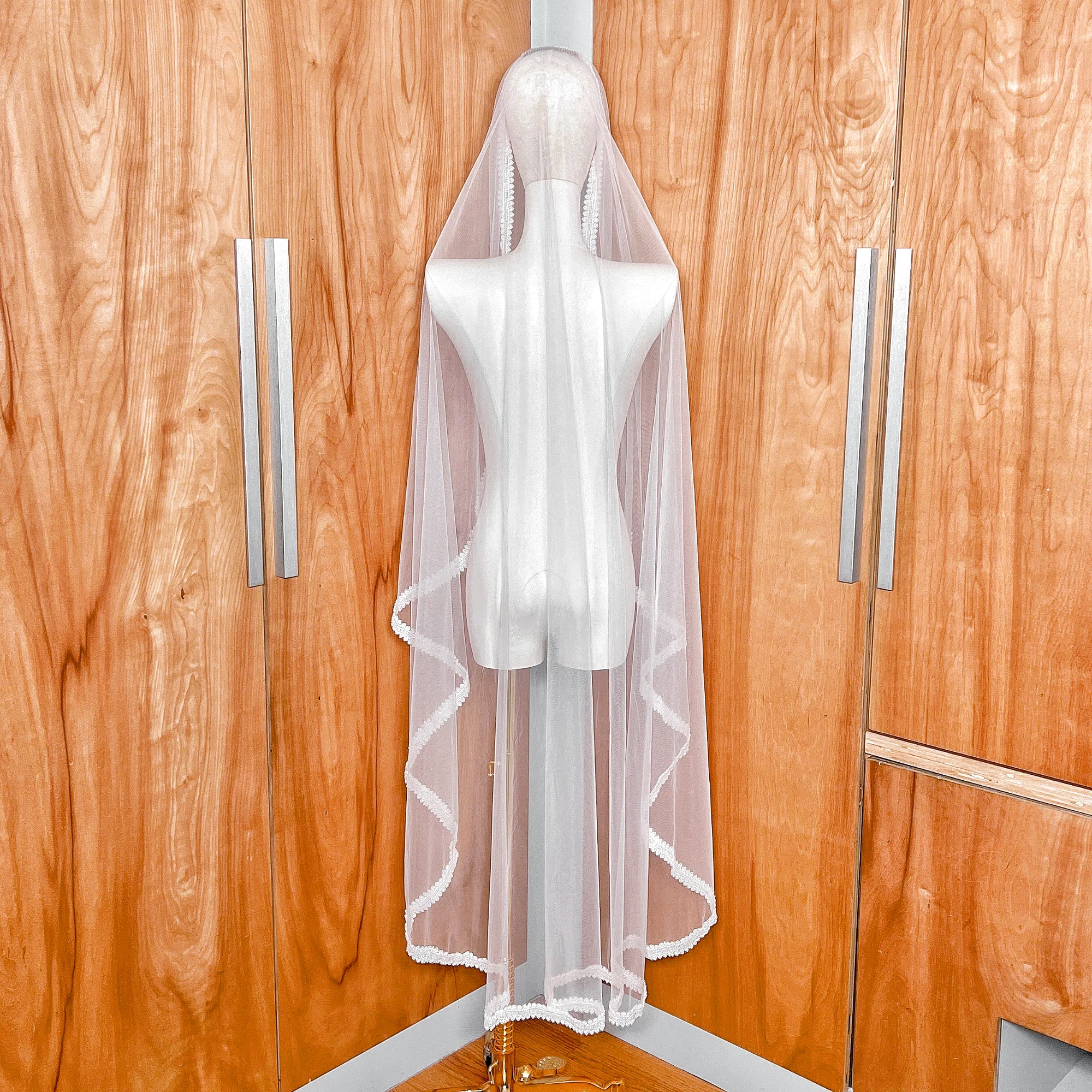 Back view showing the 60-inch waltz length and elegant drape of the beaded mantilla wedding veil on a mannequin.