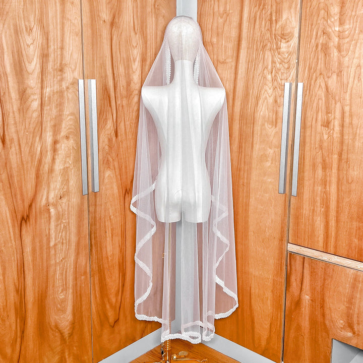 Back view showing the 60-inch waltz length and elegant drape of the beaded mantilla wedding veil on a mannequin.