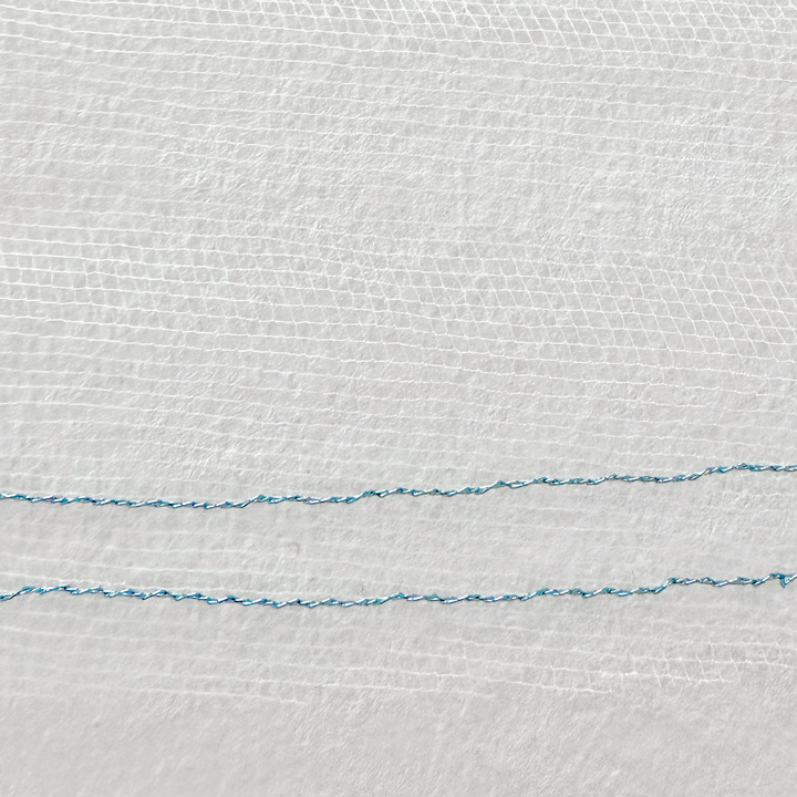 Close-up detail of the fine tulle and shiny blue metallic edge on a two tier wedding veil with blusher.