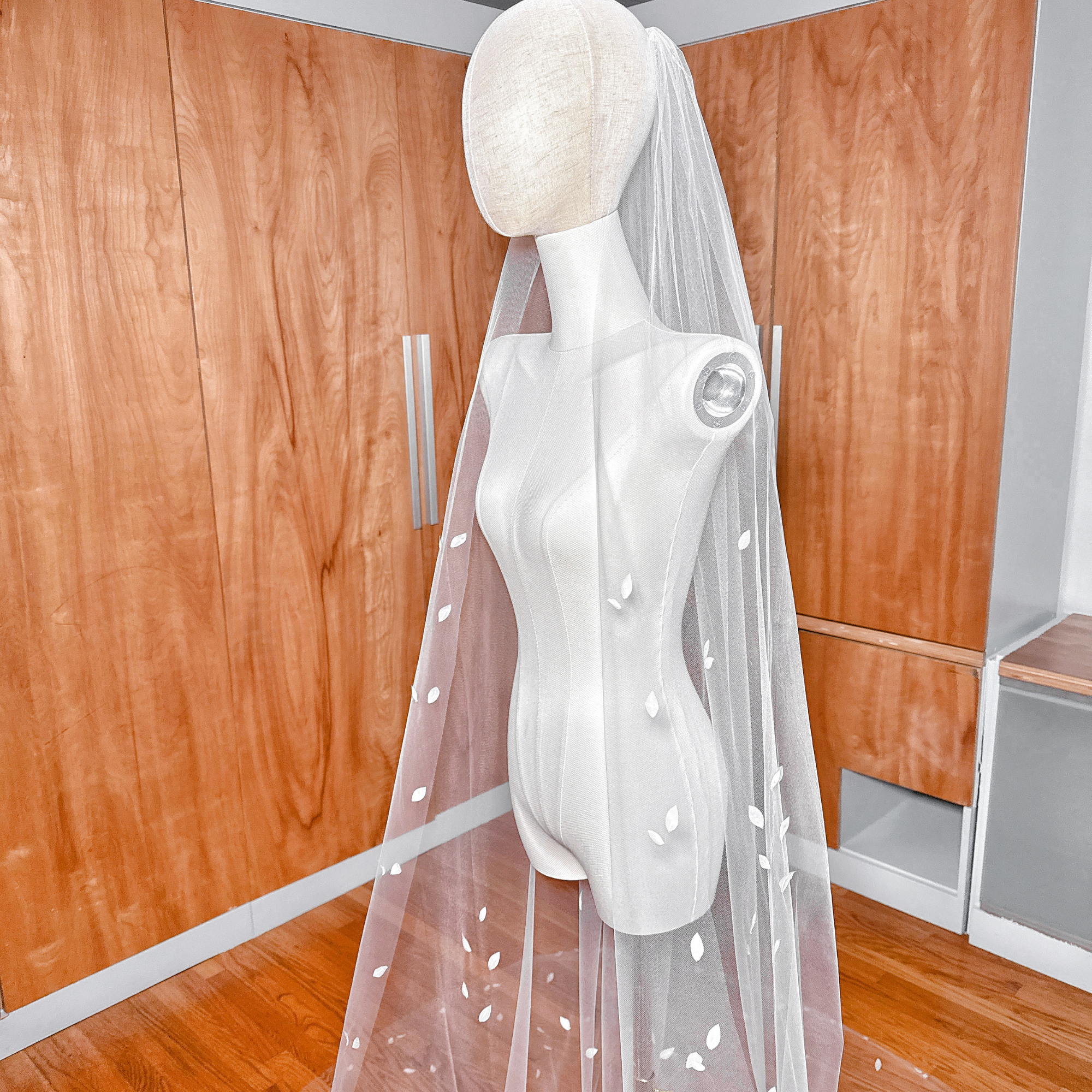 Stunning white 3D silk petal veil in cathedral length shown on a classic bridal mannequin.