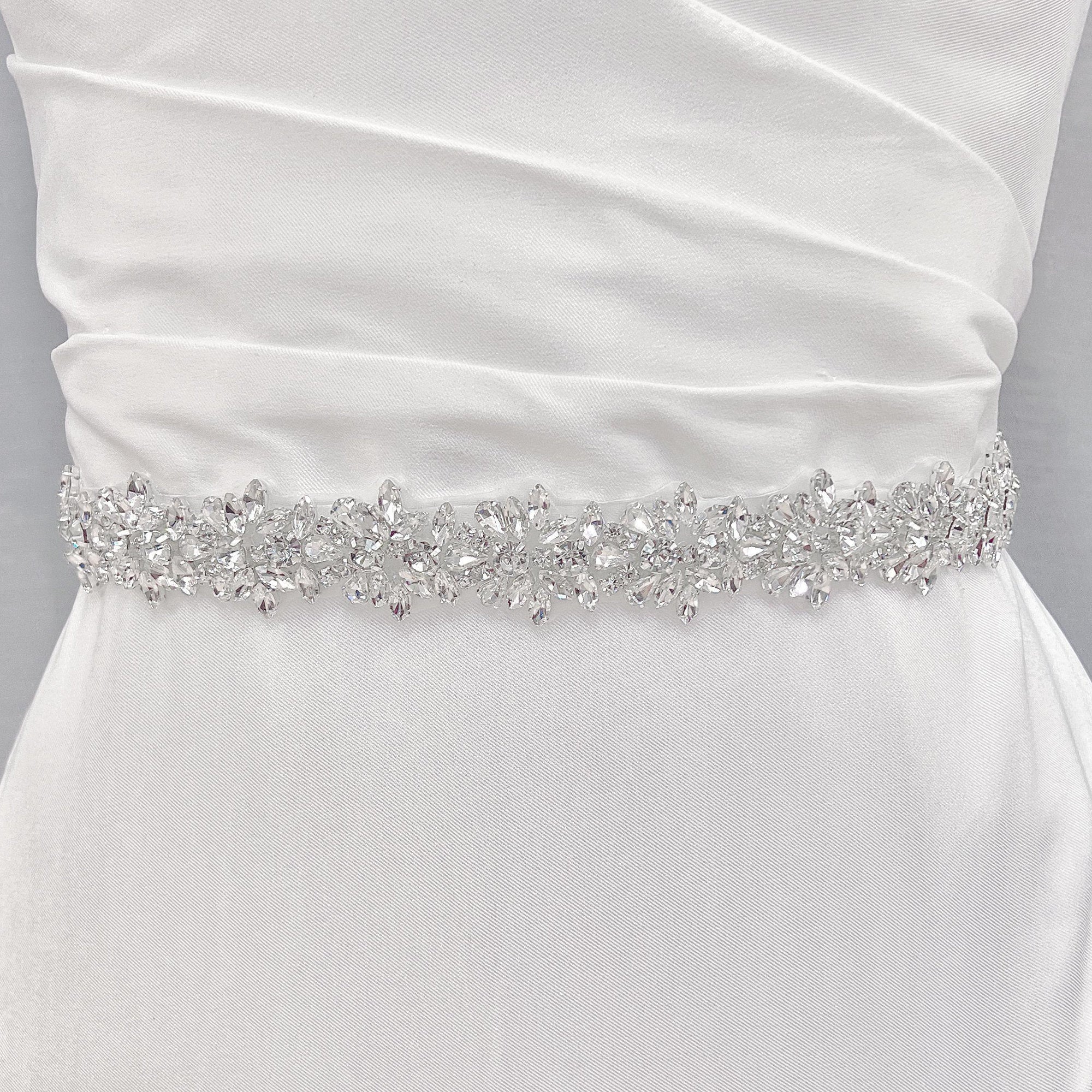A wide beaded bridal belt accentuating the waistline of an A-line wedding dress.