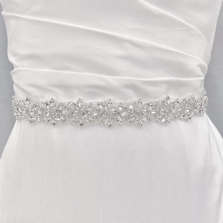 A wide beaded bridal belt accentuating the waistline of an A-line wedding dress.