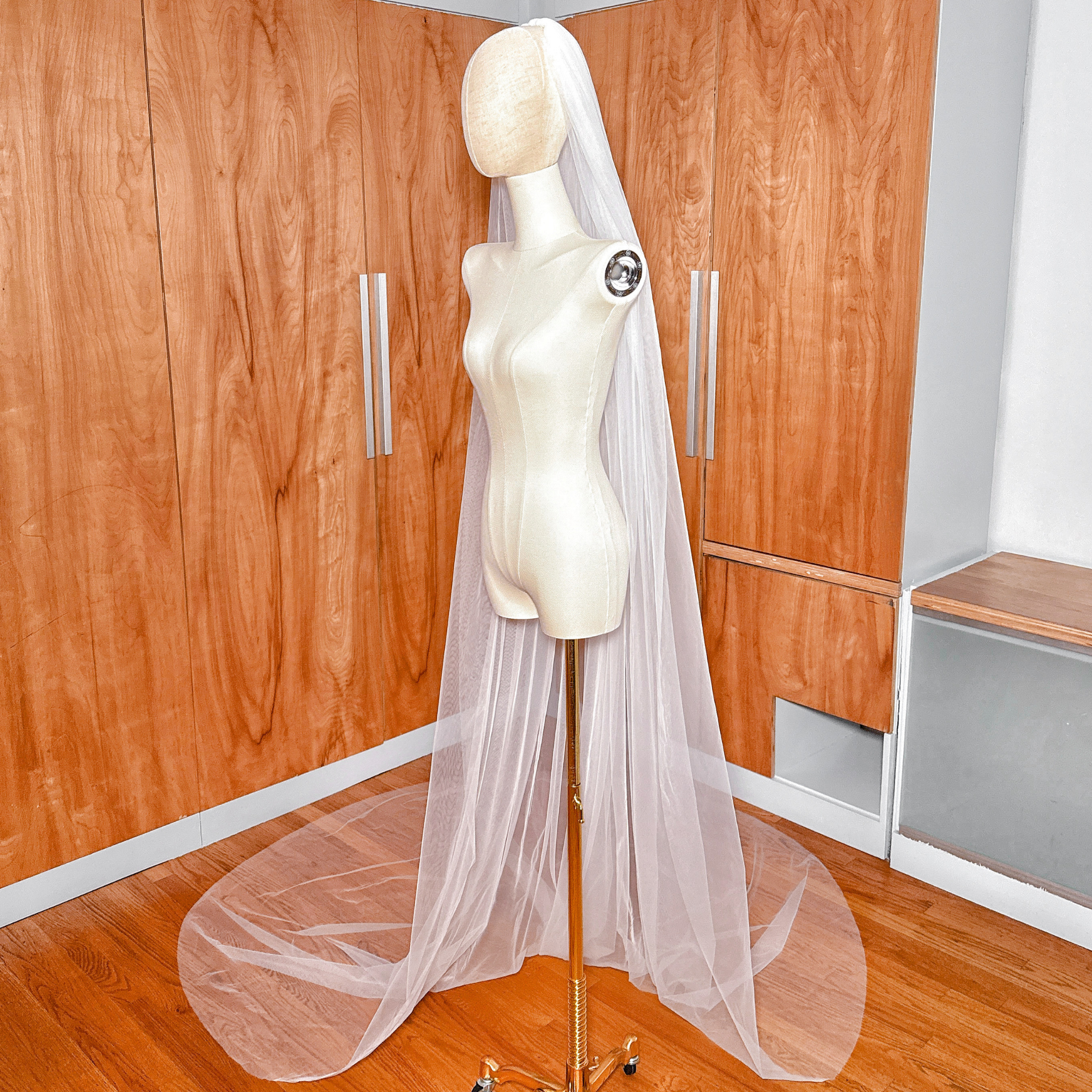 Side profile of the wide cathedral veil showing how the raw edge tulle falls softly away from the head.