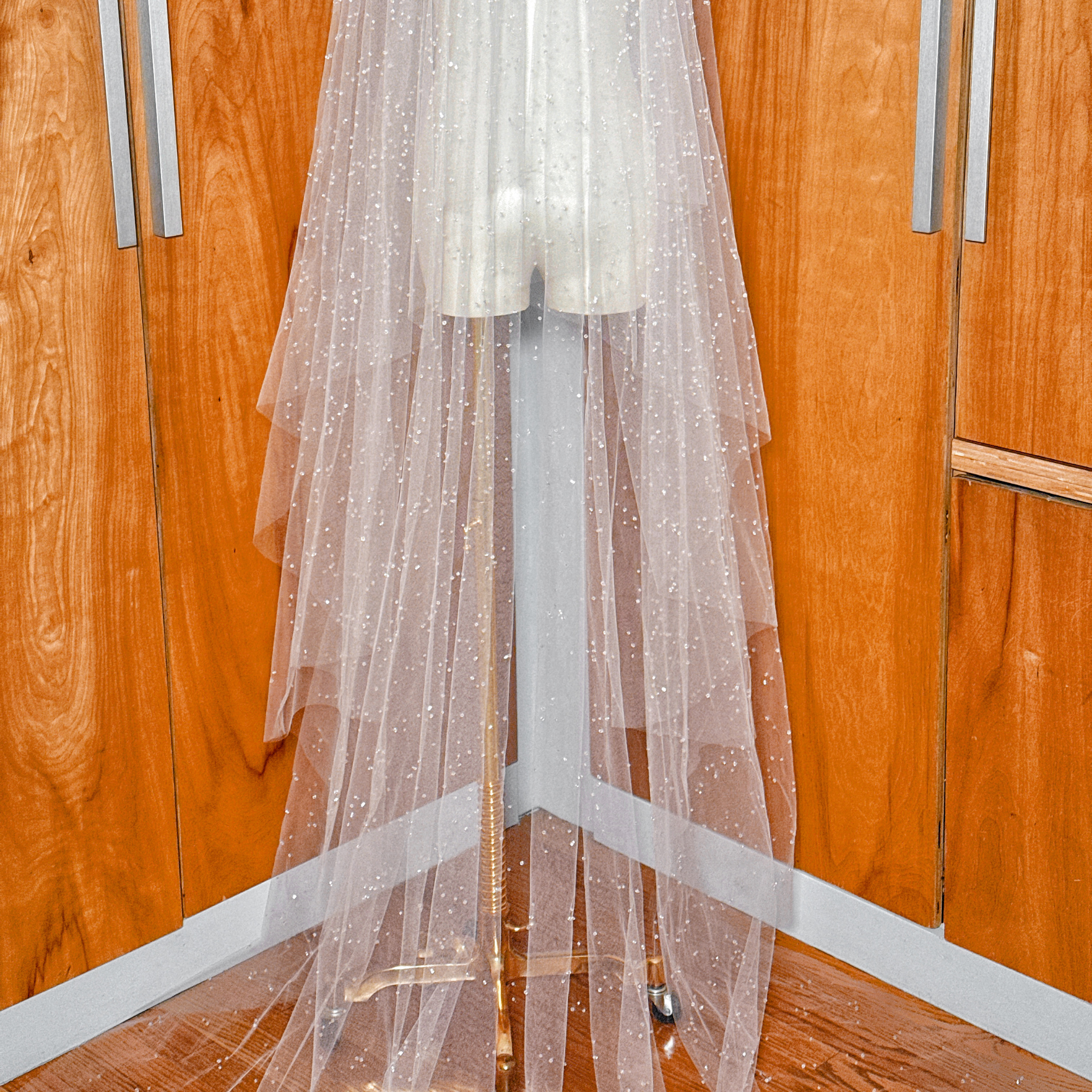 Soft white tulle of a two-tier scattered crystal beaded cathedral veil highlighting the scattered beadwork.