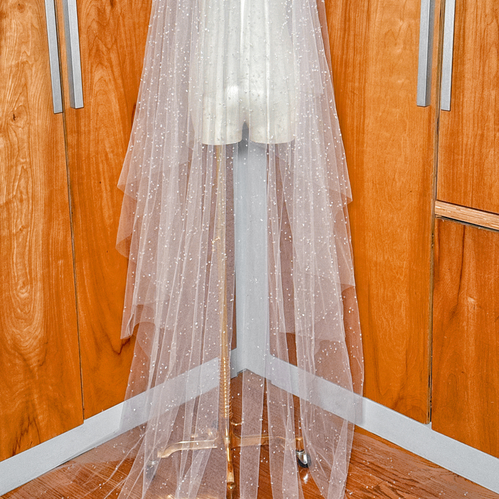 Soft white tulle of a two-tier scattered crystal beaded cathedral veil highlighting the scattered beadwork.